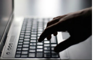 Hand on a laptop keyboard representing a Cyber Security Risk